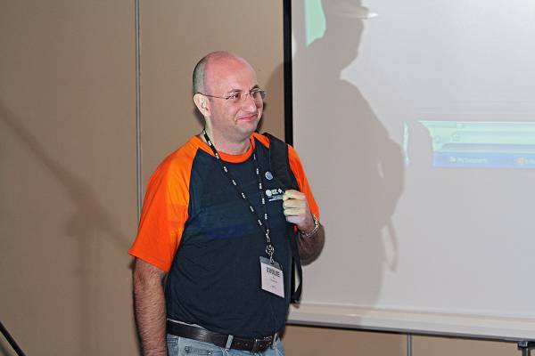 Andrew Goodchild, colour coordinated in DSTC T-Shirt  | with matching name tag,  | DSTC Farewell Symposium, 28 July 2005  | 