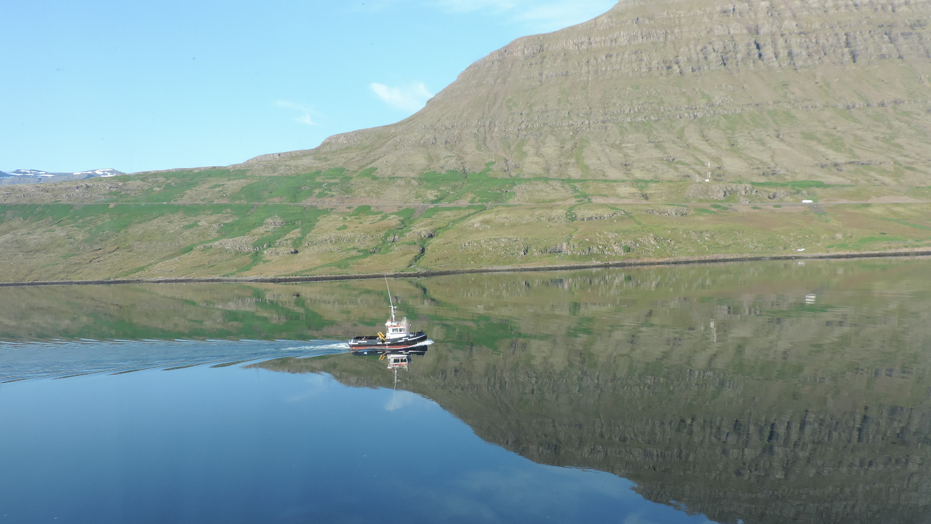 tug dwarfed in fijord